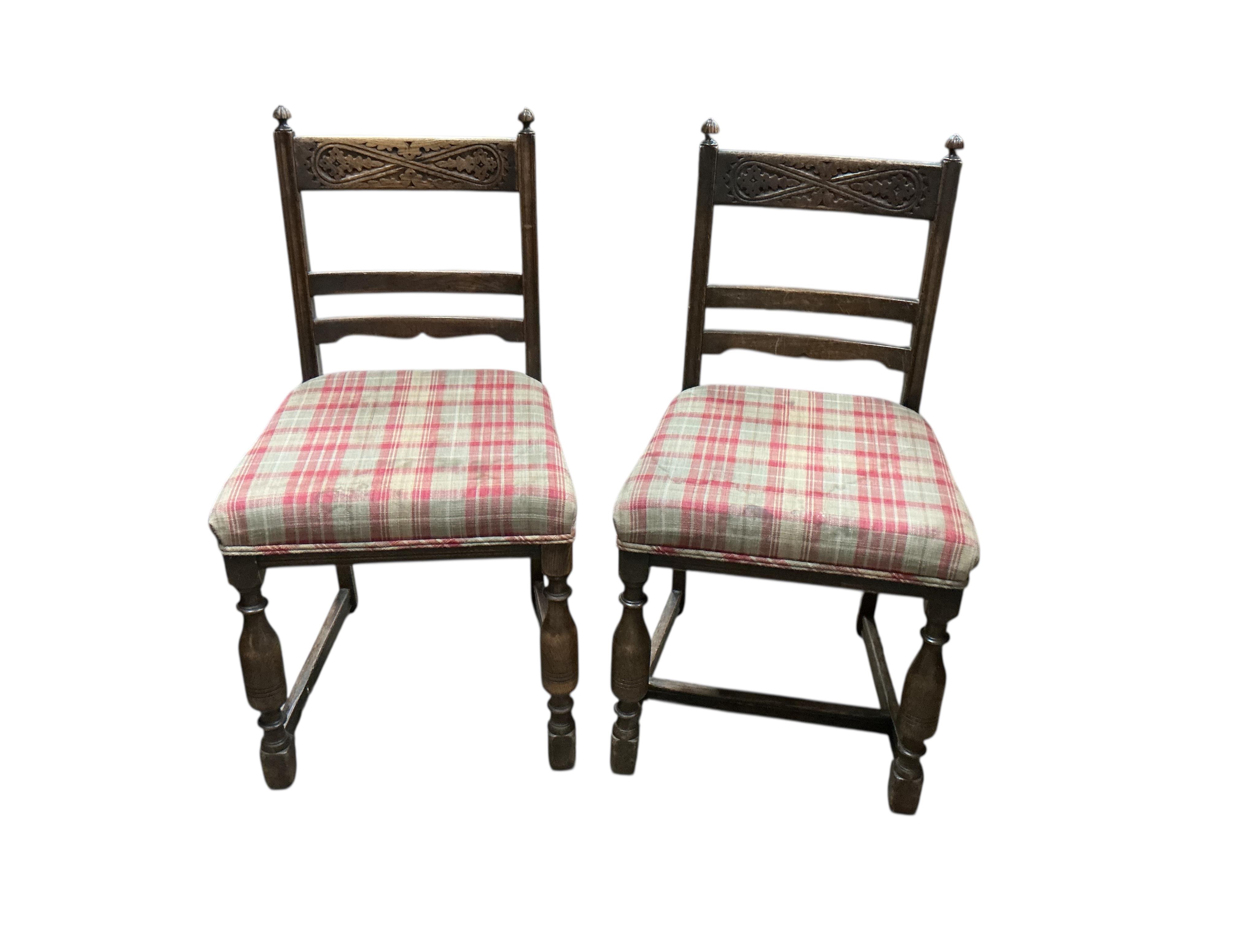 An 18th century style rectangular oak extending draw leaf refectory table, width 136cm, depth 80cm, height 78cm together with four carved oak dining chairs